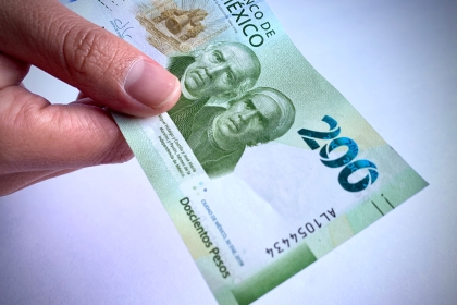 200 peso banknote being handed to someone