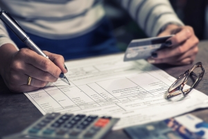 Person reviewing a bank account statement with a bank card in their hand