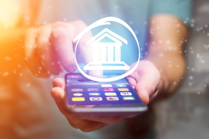 Person holding smartphone with a banking symbol above it (concept)