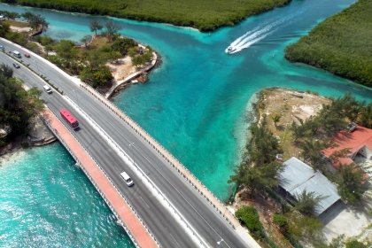 Car and bus crossing a river bridge