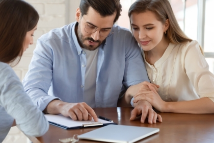 Couple talking to advisor and checking details.