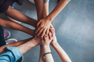 People from diverse backgrounds with their hands together