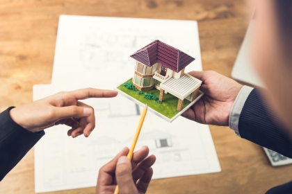 Model of a house with its blueprint in the background