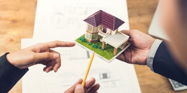 Model of a house with its blueprint in the background