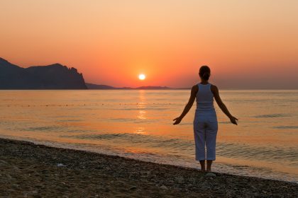 Woman on beach at sunrise