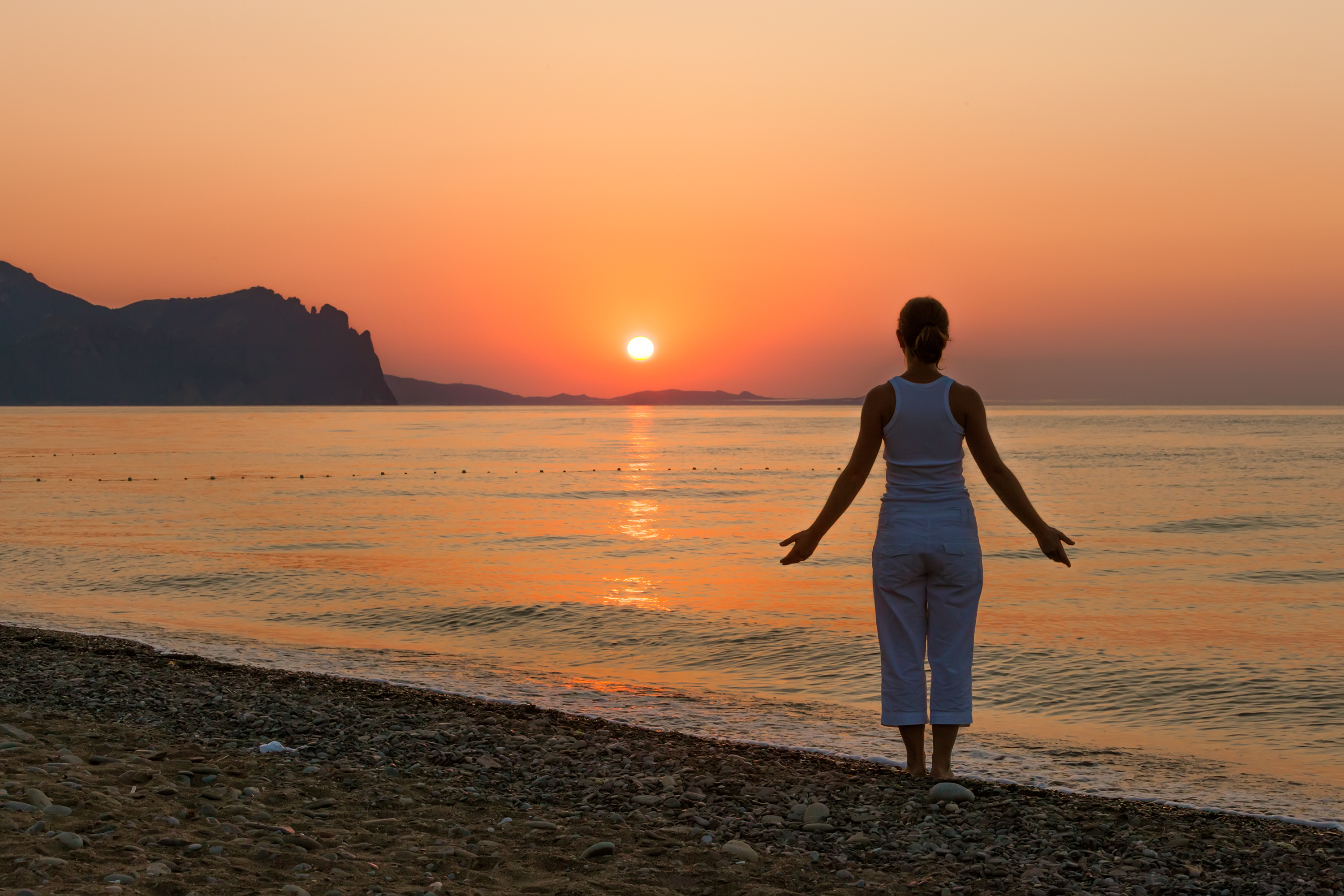 Woman on beach at sunrise